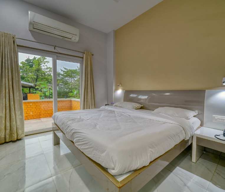 A beautifully decorated suite at The Grand Resort Igatpuri with a private balcony overlooking the mountains.